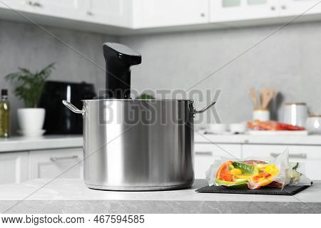 Pot With Sous Vide Cooker And Vacuum Packed Food Products On Table In Kitchen. Thermal Immersion Cir