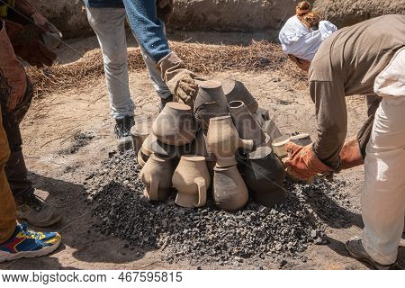 Amarante, Portugal - Circa April 2022: Stacking The Pieces Of Clay On The Embers Of The Bonfire Duri