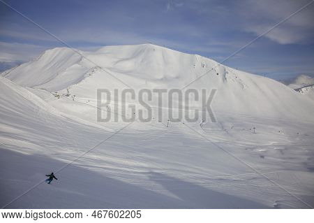 Great View Of Freerider On Splitboard Riding Down From Top Of Ridge. Ski Touring In Mountains. Gudau