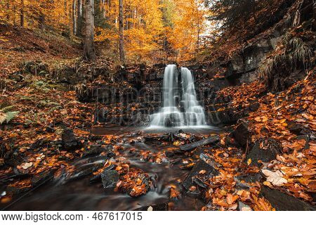 Wonderful Cascading Waterfall Bystry Covered And Surrounded By Autumn Leaves And Trees Glowing Orang