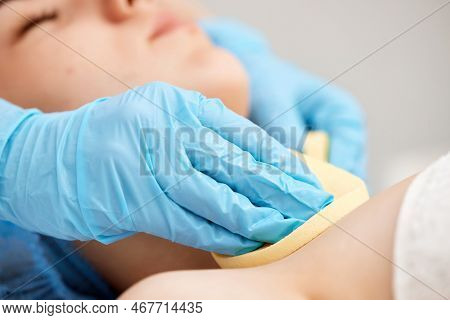 Beautician Cleanses Skin Of Beautiful Woman With A Sponge.