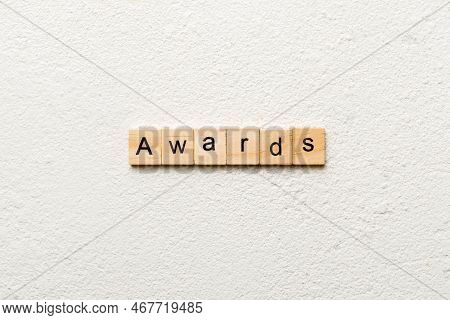 Awards Word Written On Wood Block. Awards Text On Cement Table For Your Desing, Concept.