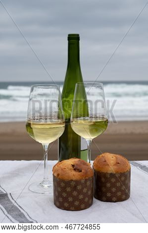 Sweet Fruit Christmas And New Year Cake Panettone With Two Glasses Of Txakoli White Wine Served On S