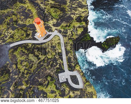 Top Down Aerial View Of An Orange Svortuloft Lighthouse In West Iceland By The Sea