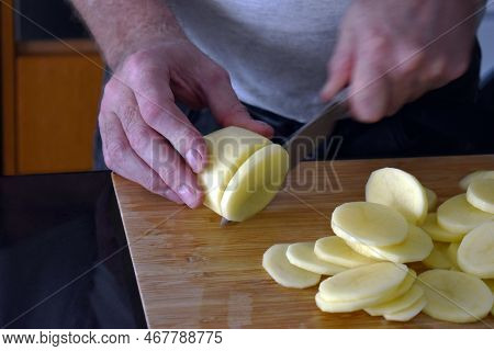 Man Cutting Potatoes. Cooking Preparation Concept. Baked Potatoes Preparation.