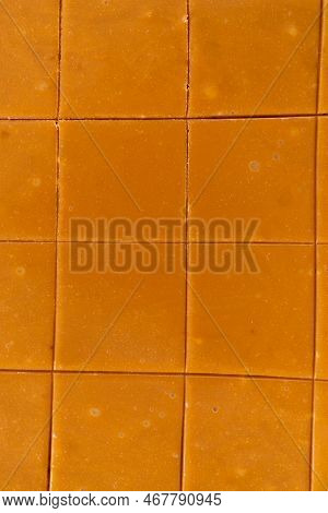Scoring Caramel Fudge Using A Wheel Dough Cutter For Cutting Into Small Square Pieces.