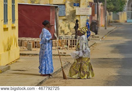Saint-louis. Senegal. October 10, 2021. Two Women In National Clothes Under The Merciless Sun Discus