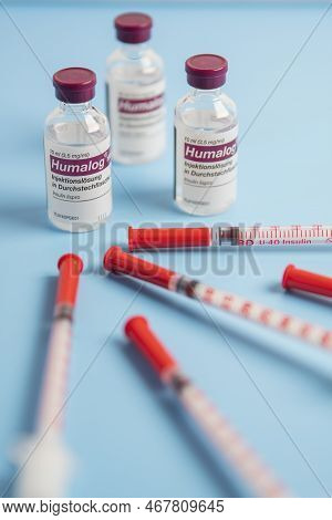 Insulin Injection Syringe Arranged Around Humalog Insulin Injection Solution  On Blue Background.sid