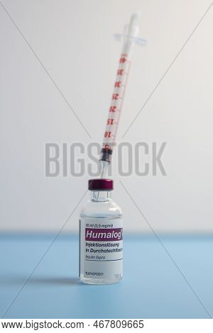 Insulin Injection Syringe In A  Humalog Insulin Injection Solution  On Blue Background.side View
