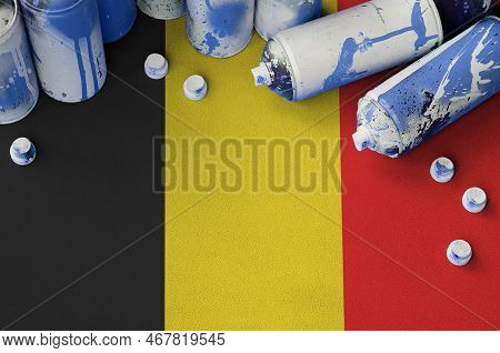 Belgium Flag And Few Used Aerosol Spray Cans For Graffiti Painting. Street Art Culture Concept, Vand