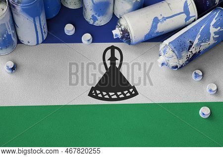 Lesotho Flag And Few Used Aerosol Spray Cans For Graffiti Painting. Street Art Culture Concept, Vand