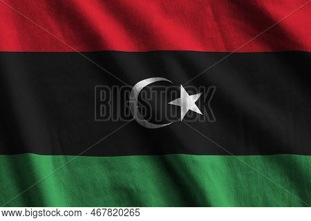 Libya Flag With Big Folds Waving Close Up Under The Studio Light Indoors. The Official Symbols And C