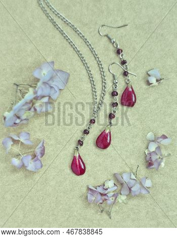 Close Up Craft Jewellery Set With Red Petals And Fresh Flowers Concept Photo. Top View Photography W
