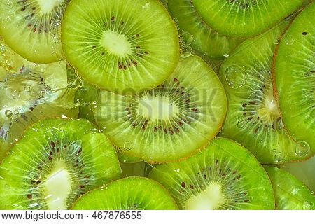Slices Of Kiwi Fruit In Water On White Background. Kiwi Fruit Close-up In Liquid With Bubbles. Slice