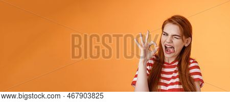 Sassy Asserive Relaxed Redhead Woman Assuring Everything Under Control, Make Deal, Wink Show Tongue 
