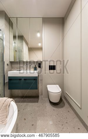 Modern Bright Bathroom With Beige Wall. Washbasin With Turquoise Cupboard And Mirror. Wall With Mold