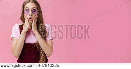 Waist-up Shot Of Sylish Young Girl With Tattoo And Wavy Pretty Natural Hairstyle Pressing Palms To C
