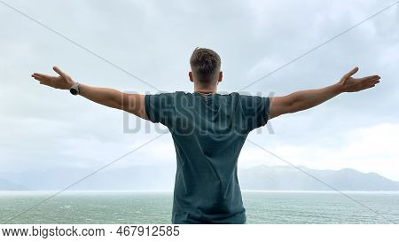 Happy Handsome Free Guy, Young Calm Relaxed Carefree Man Traveler With Open Raised Hands Enjoy Sea, 