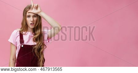 Waist-up Shot Of Arrogant Young Girl With High Ego Grimacing Snobbish Showing Letter L On Forehead M