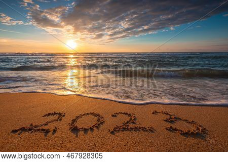 Happy New Year 2023 Text On The Beach Sand During Scenic Morning. Sunrise Over The Sea Shore.