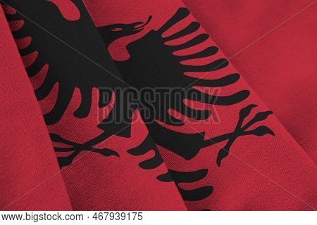 Albania Flag With Big Folds Waving Close Up Under The Studio Light Indoors. The Official Symbols And