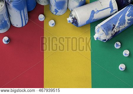 Guinea Flag And Few Used Aerosol Spray Cans For Graffiti Painting. Street Art Culture Concept, Vanda