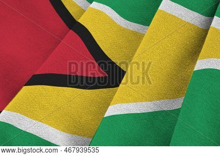 Guyana Flag With Big Folds Waving Close Up Under The Studio Light Indoors. The Official Symbols And 