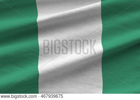 Nigeria Flag With Big Folds Waving Close Up Under The Studio Light Indoors. The Official Symbols And