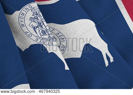 Wyoming Us State Flag With Big Folds Waving Close Up Under The Studio Light Indoors. The Official Sy