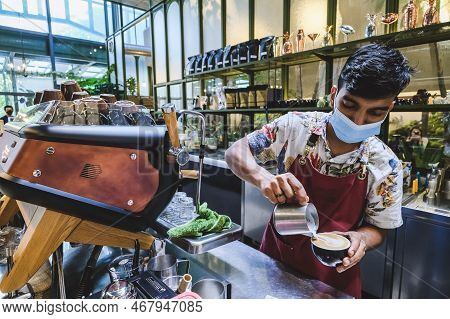 Kuala Lumpur, Malaysia - Februry 23, 2022: Professional Barista Poured Hot Milk Into A Hot Espresso 