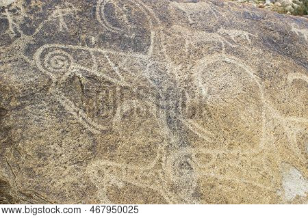 Petroglyphs On The Rocks In Kazakhstan. The Ancient Parking Cave Man. Historical Cave Paintings. Car
