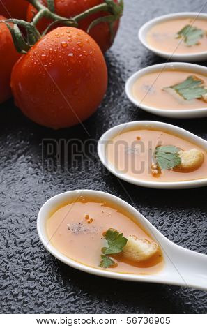 Gazpacho in einer Gruppe von kleine Löffel auf eine Tabelle-Schiefer