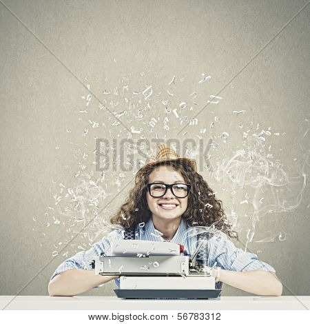 Young funny woman in glasses using typewriter