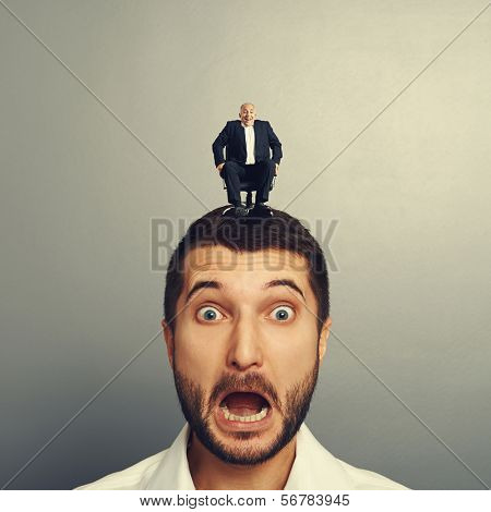 screaming scared man with laughing boss on the head