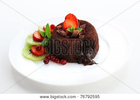 Hot chocolate pudding with fondant centre with fruits, isolated on white