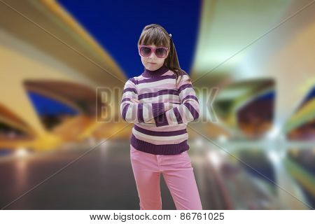 Teenage girl in pink wears sunglasses with modern city in background