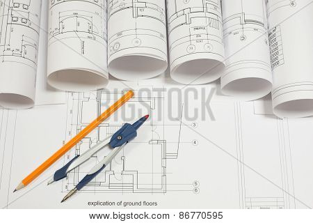 Drawing compasses, pencil and architectural drawings scrolls