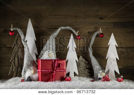 Funny natural christmas decoration in grey, white and red with gift boxes and imps on the old wooden background.