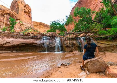 Girl Sitting In Front Of Waterfall
