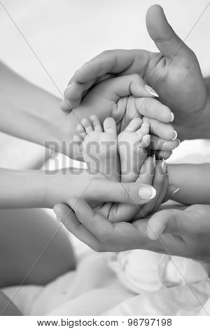 Happy family of mother and father holding bare feet