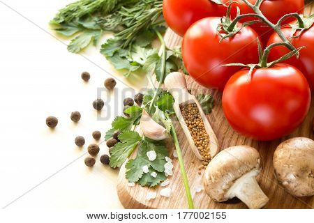 Ingredients for cooking sauce. Sprig of tomatoes parsley garlic mushrooms pepper pots mustard seeds.