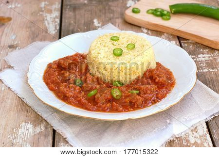 Perkelt From Beef Meat, Peper And Tomato With Bulghur On White Plate On Wooden Background