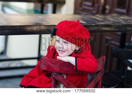 Portrait Of A Beautiful Little Girl With Red Hair In A Red Coat