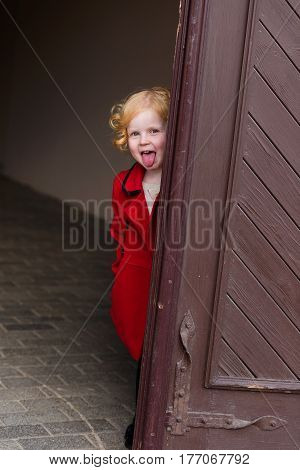 Portrait Of A Beautiful Little Girl With Red Hair In A Red Coat