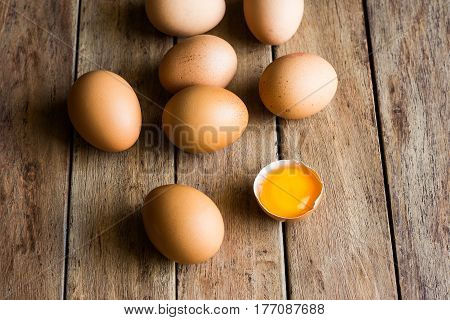 Fresh organic eggs scattered on wood kitchen table cracked shell with open yolk soft daylight baking Easter concept top view