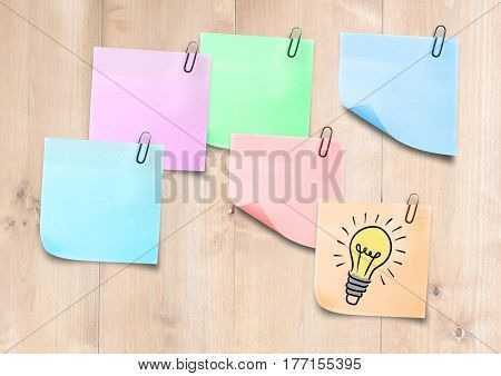 Digital composite of Sticky Notes Bulb Idea Icon against a light wood background