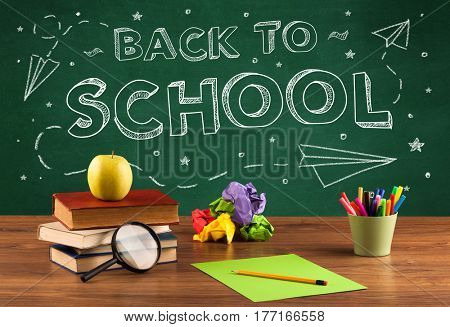 Back to school concepty with writing on blackboard and desk, apple, books, items