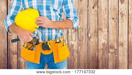 Digital composite of Carpenter with hammer against wood panel