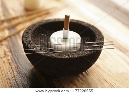 Acupuncture supplies on wooden background