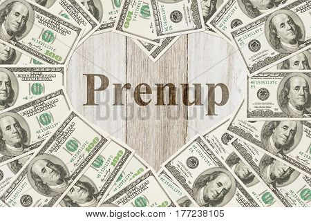 Money and marriage message One hundred dollar bill in the shape of a heart with a weathered wood heart with text Prenup